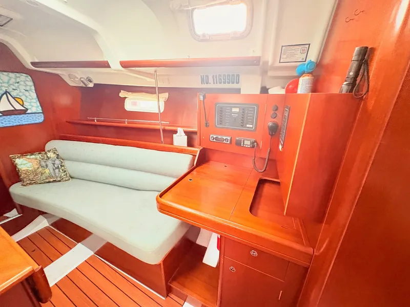 Slide: The Image of Interior of a 2005 Beneteau Oceanis Clipper 343 with wooden furnishings and a gray sofa. - 23
