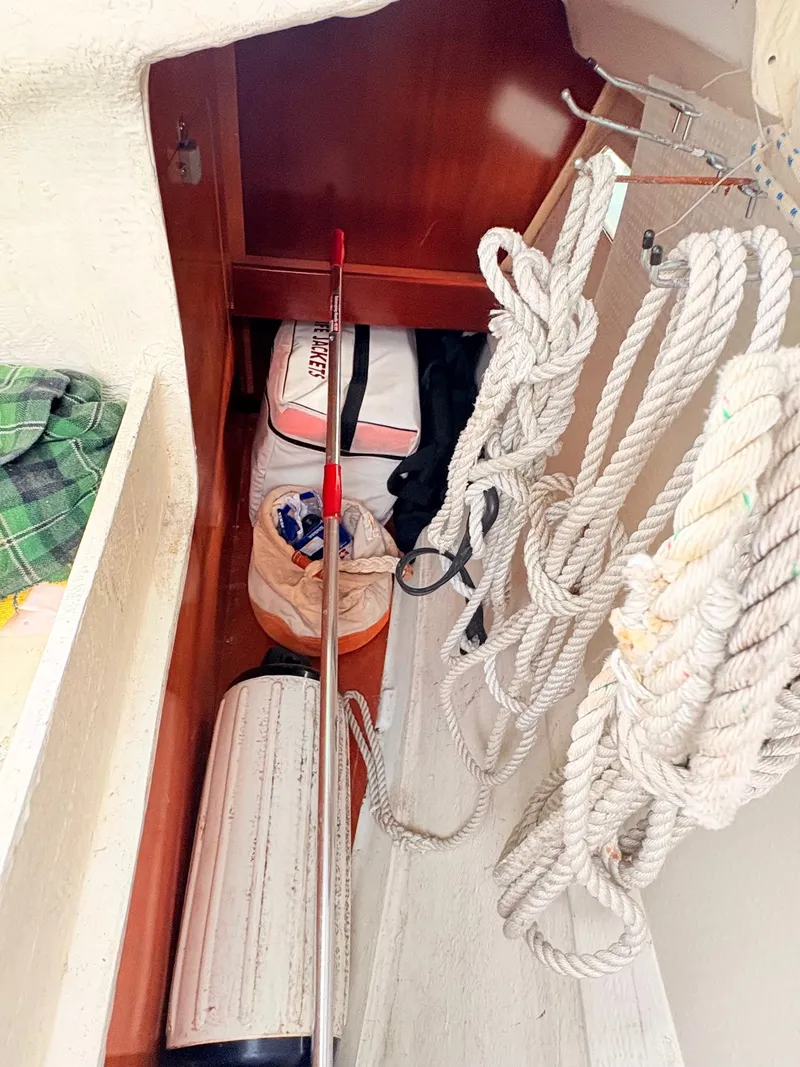 Slide: The Image of A storage area on a sailboat with ropes, bags, and a paddle. - 17