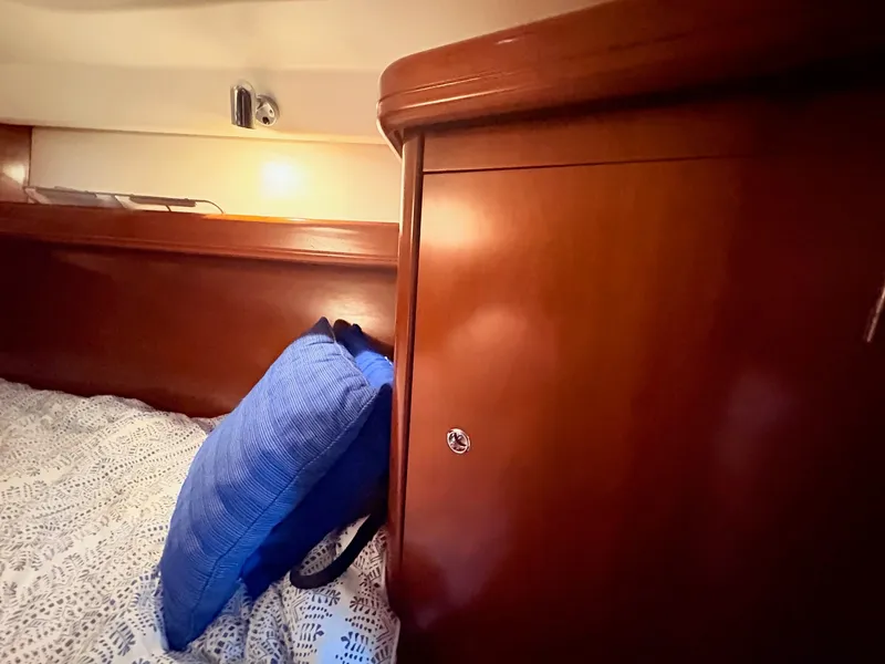 Slide: The Image of The cabin of a 2005 Beneteau Oceanis Clipper 343 with wooden furnishings and a blue pillow. - 37