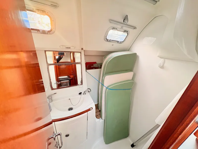 Slide: The Image of The image shows the bathroom of a 2005 Beneteau Oceanis Clipper 343 with a sink and mirror. - 21