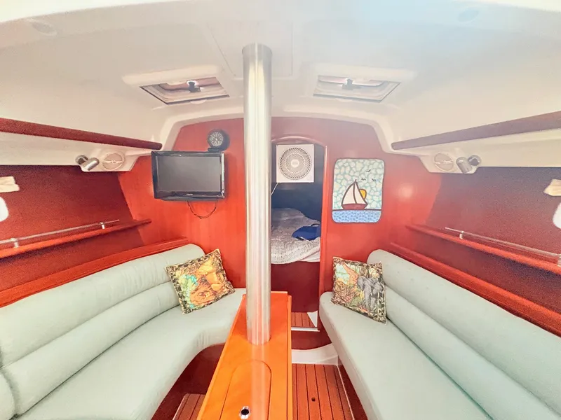 Slide: The Image of Interior of a 2005 Beneteau Oceanis Clipper 343 with cozy seating and a small TV. - 34