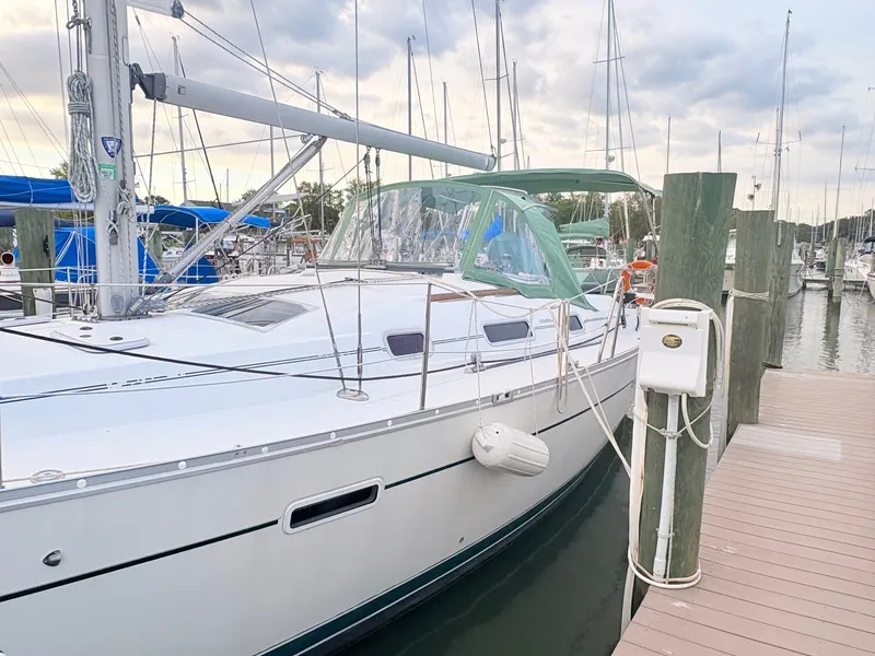 Slide: The Image of A 2005 Beneteau Oceanis Clipper 343 docked, featuring a green bimini top. - 1