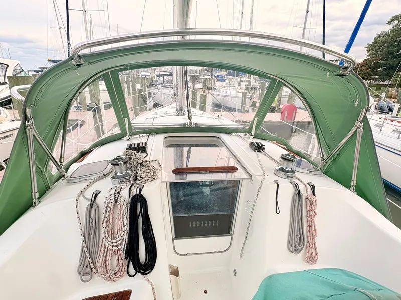 Slide: The Image of The cockpit of a 2005 Beneteau Oceanis Clipper 343 with a green canopy and ropes. - 6