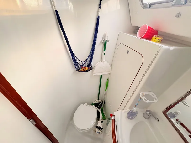 Slide: The Image of The image shows a boat bathroom with a toilet, sink, and cleaning supplies. - 22