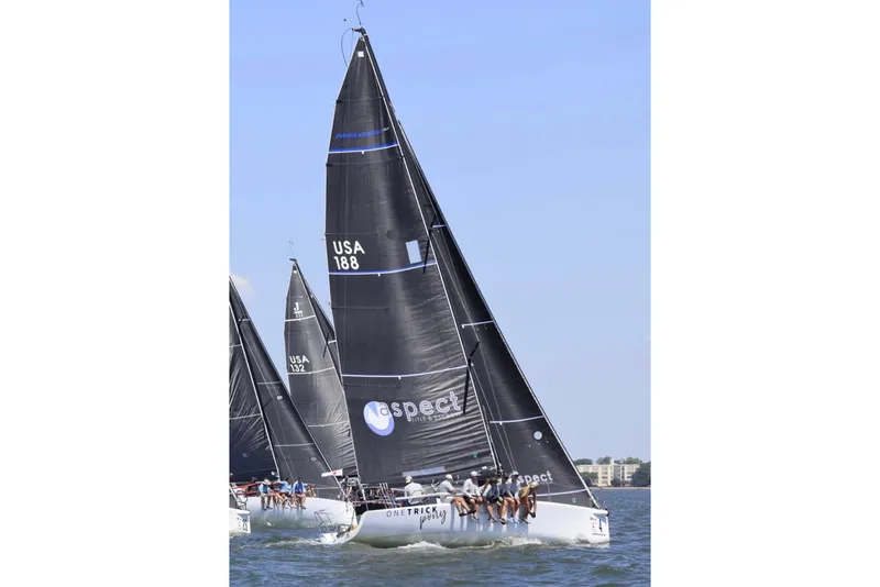 Slide: The Image of Sailing race featuring a 2008 Melges 32 yacht with black sails on open water. - 0