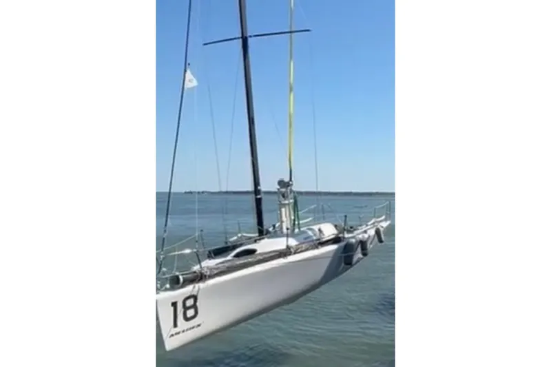 Slide: The Image of Sailing yacht Melges 32 (2008) suspended above water, showcasing sleek design and number 18. - 2