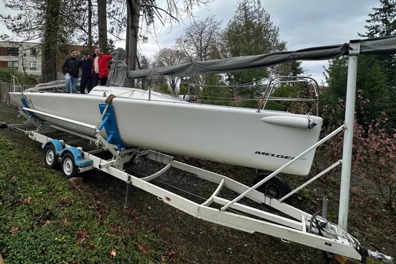 Slide: The Image of 2008 Melges 32 sailboat on trailer with three people standing beside it. - 5