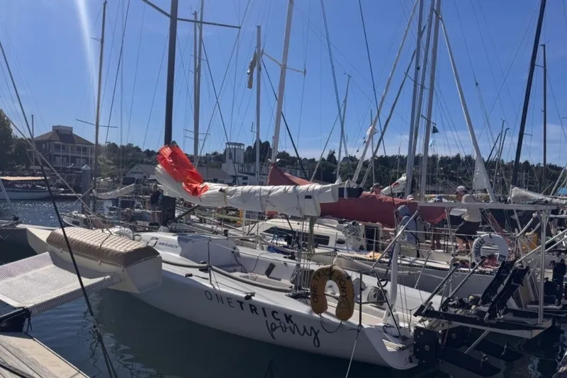 Slide: The Image of 2008 Melges 32 sailboat docked at a marina under clear blue skies. - 6