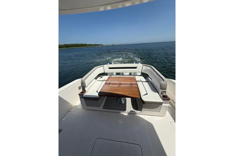 Slide: The Image of 2022 Tiara Yachts 38 LS boat interior with elegant seating and wooden table on open water. - 21