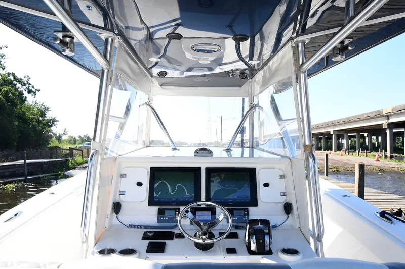 Slide: The Image of 2014 Invincible 42 Open Fisherman boat cockpit with dual navigation screens and steering wheel. - 15