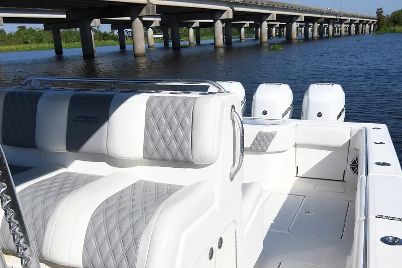 Slide: The Image of 2014 Invincible 42 Open Fisherman boat with luxurious seating, docked near a bridge. - 18
