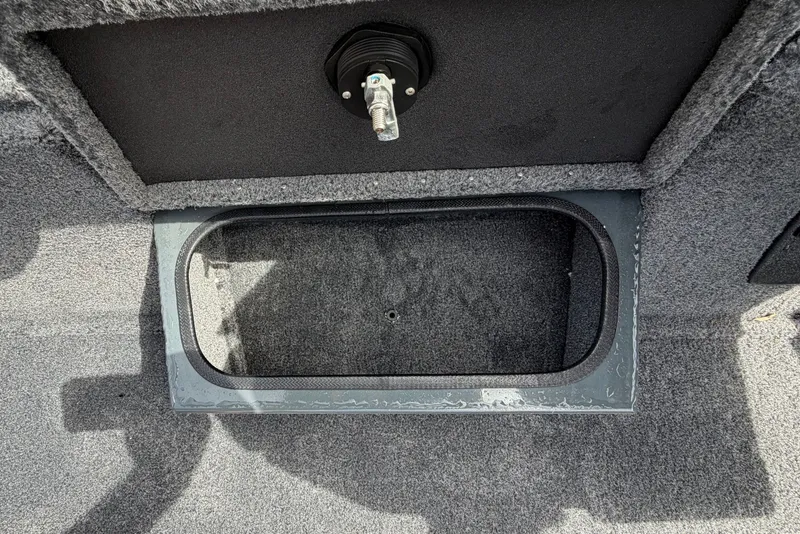 Slide: The Image of Open storage compartment on 2027 Ranger RT188P boat, featuring carpeted interior and latch mechanism. - 12