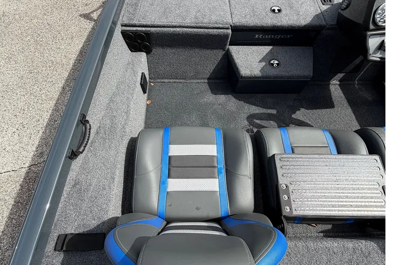 Slide: The Image of 2027 Ranger RT188P boat interior with gray and blue seating, carpeted flooring. - 14
