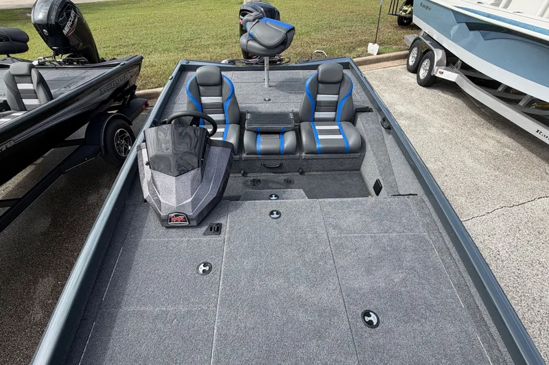 Slide: The Image of 2027 Ranger RT188P fishing boat with dual seats and steering console, parked on pavement. - 9