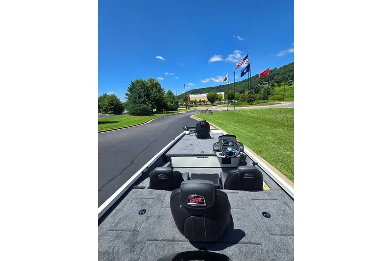 Slide: The Image of 2027 Ranger RT188 boat on road with flags and scenic background. - 9