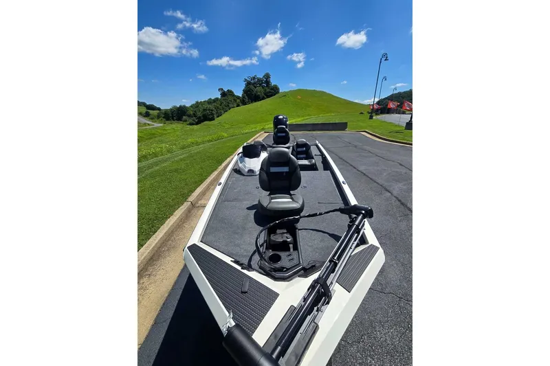 Slide: The Image of 2027 Ranger RT188 boat on pavement, sunny day, green hills in background. - 7