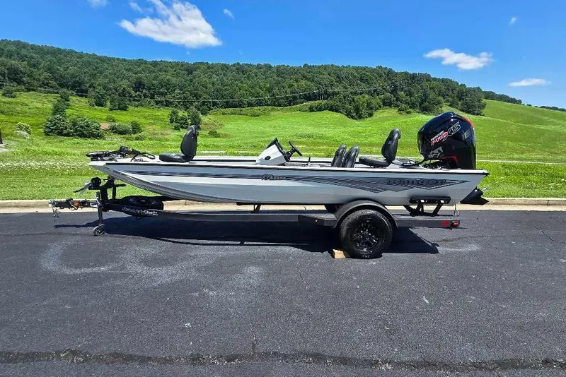 The Image of 2027 Ranger RT188 boat on trailer, parked on asphalt with green hills in background. - 0