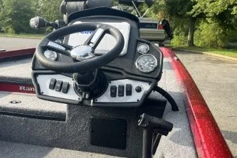 Slide: The Image of 2027 Ranger RT178 boat dashboard with steering wheel and control panel in a parking area. - 6