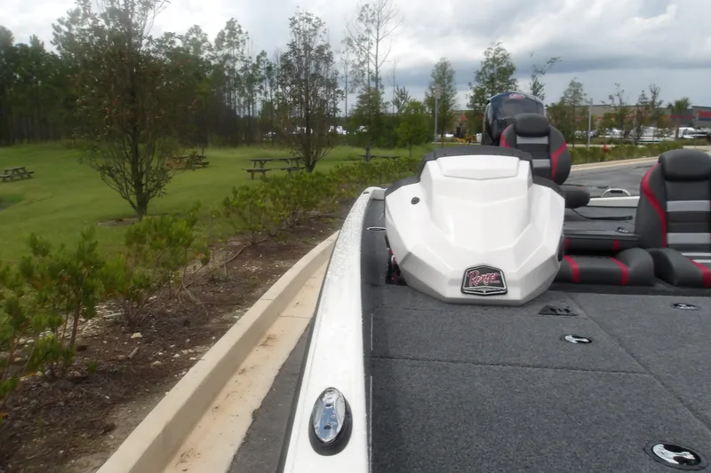 Slide: The Image of 2027 Ranger RT198P boat with sleek design, parked near a grassy area with trees. - 14