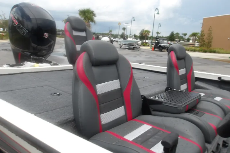 Slide: The Image of 2027 Ranger RT198P boat interior with gray and red seats, parked outdoors. - 15