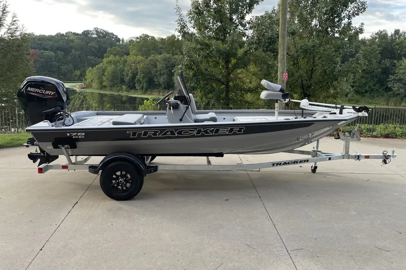 The Image of 2027 Tracker Bass Tracker 175 CC boat on trailer, parked outdoors near trees. - 0
