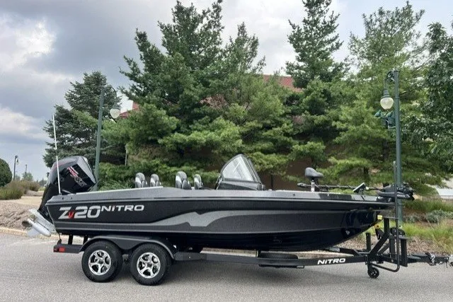 Slide: The Image of 2027 Nitro ZV20 Pro boat on trailer, parked near trees under cloudy sky. - 2