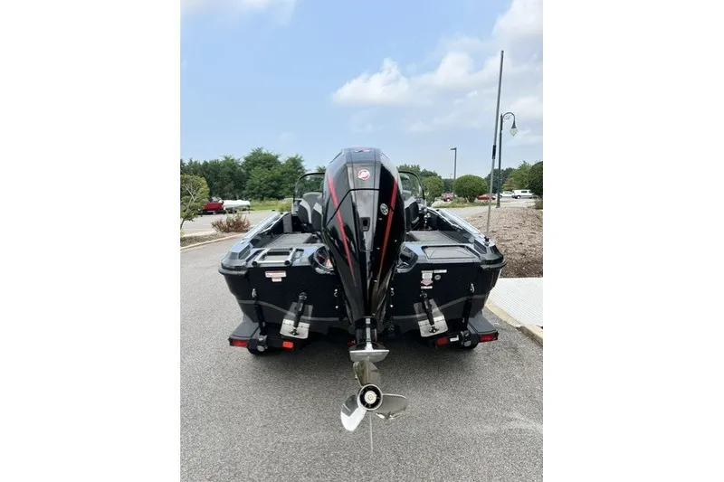 Slide: The Image of 2027 Nitro ZV20 Pro boat, rear view, parked on a road with trees and cloudy sky. - 8