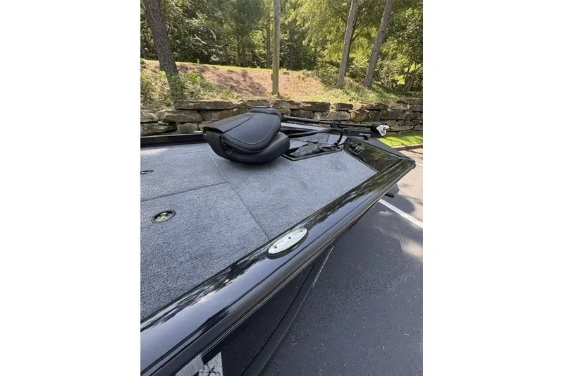 Slide: The Image of 2027 Ranger RT178 boat deck with seat, surrounded by trees and stone wall. - 5