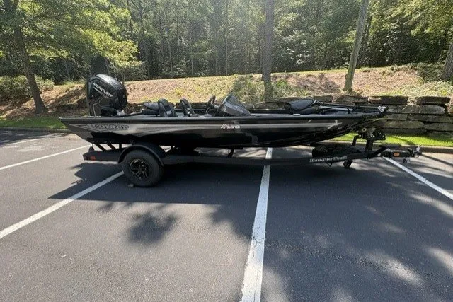 Slide: The Image of 2027 Ranger RT178 boat parked in a wooded area, side view. - 1