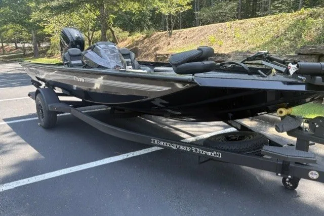 Slide: The Image of 2027 Ranger RT178 boat on trailer in parking lot, surrounded by trees. - 2