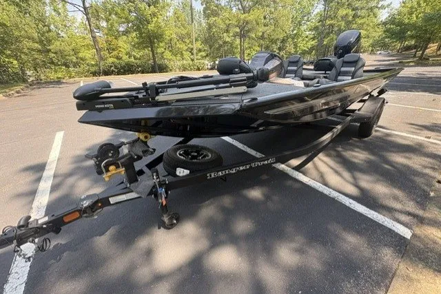 Slide: The Image of 2027 Ranger RT178 boat on trailer in parking lot, surrounded by trees. - 9