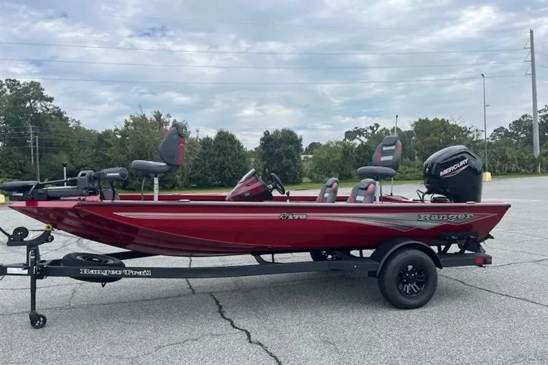 Slide: The Image of 2027 Ranger RT178 boat in red, parked on a trailer in an outdoor setting. - 2