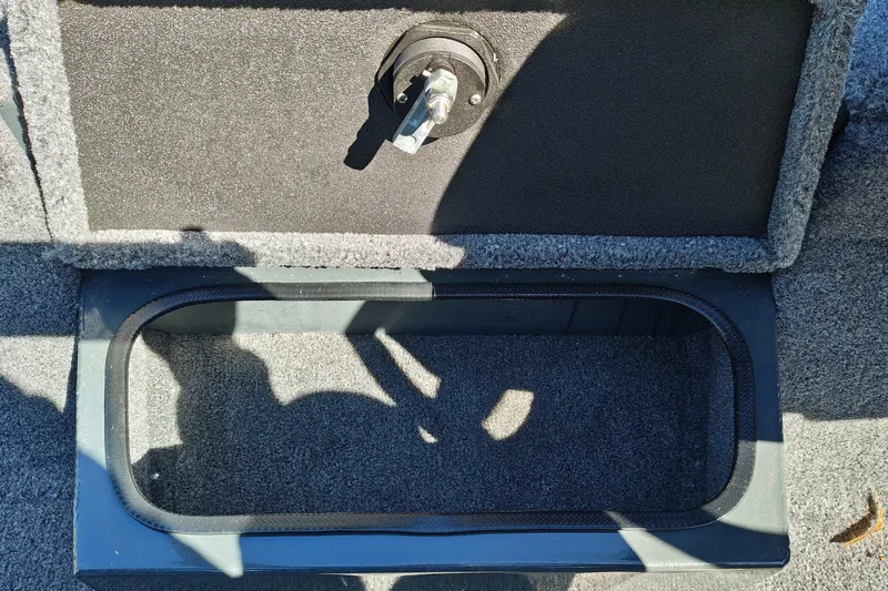 Slide: The Image of Open storage compartment in 2027 Ranger RT198P boat, featuring carpeted interior and latch. - 27