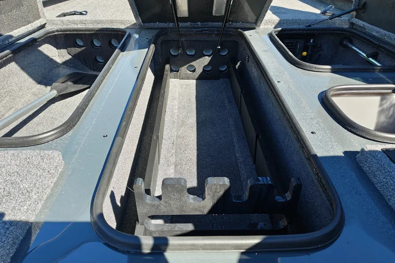 Slide: The Image of 2027 Ranger RT198P boat interior storage compartments with rod holders and carpeted finish. - 28