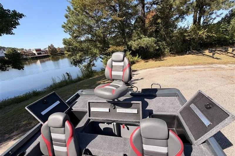 Slide: The Image of 2027 Ranger RT188P boat interior with seats and storage compartments by a lake. - 20