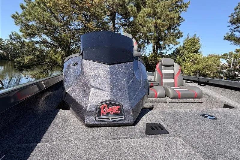 Slide: The Image of 2027 Ranger RT188P boat with sleek design, gray and red seating, surrounded by trees. - 16