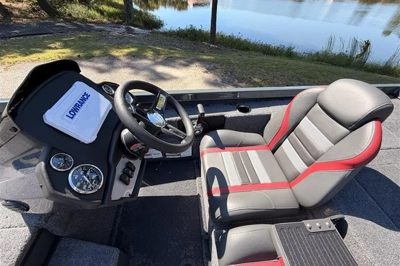 Slide: The Image of 2027 Ranger RT188P boat cockpit with steering wheel and cushioned seat by a lake. - 14