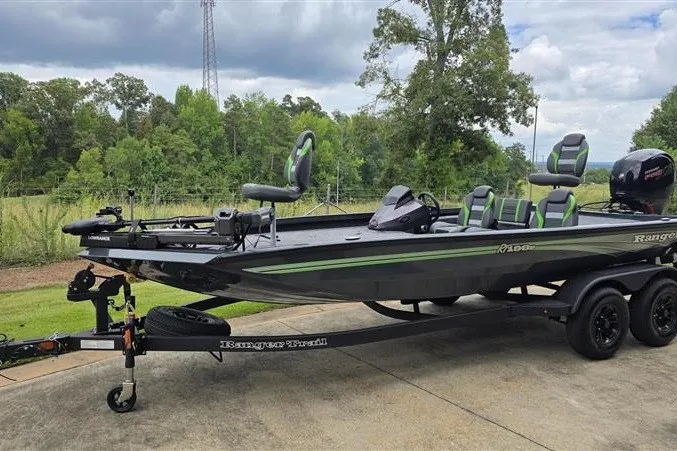 Slide: The Image of 2027 Ranger RT198P fishing boat on trailer, parked outdoors with lush greenery background. - 8