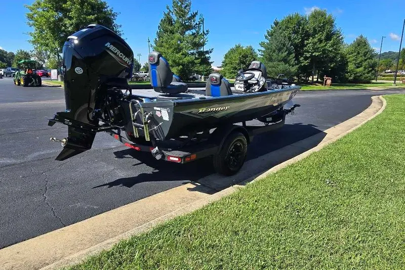 The Image of 2027 Ranger RT178 boat with Mercury engine on a trailer in a sunny park setting. - 0