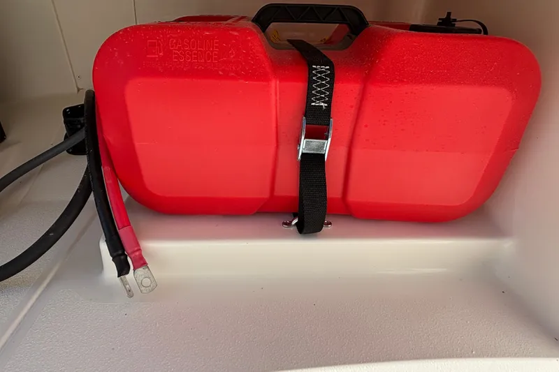 Slide: The Image of Red gasoline tank secured in a 2026 Mako Pro Skiff 13 CC boat compartment. - 14