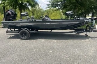 Slide: The Image of 2027 Ranger RT188C fishing boat on trailer, parked outdoors with trees in background. - 3