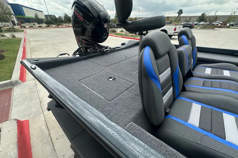 Slide: The Image of 2027 Ranger RT188C boat interior with gray and blue seating, parked outdoors. - 21