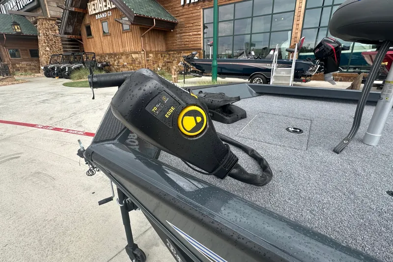 Slide: The Image of 2027 Ranger RT188C boat with trolling motor, displayed outside a rustic store. - 6