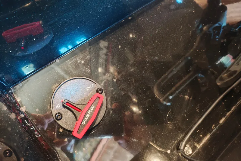 Slide: The Image of Close-up of a 2027 Ranger RT178 drain plug with "IN" and "OUT" settings. - 49