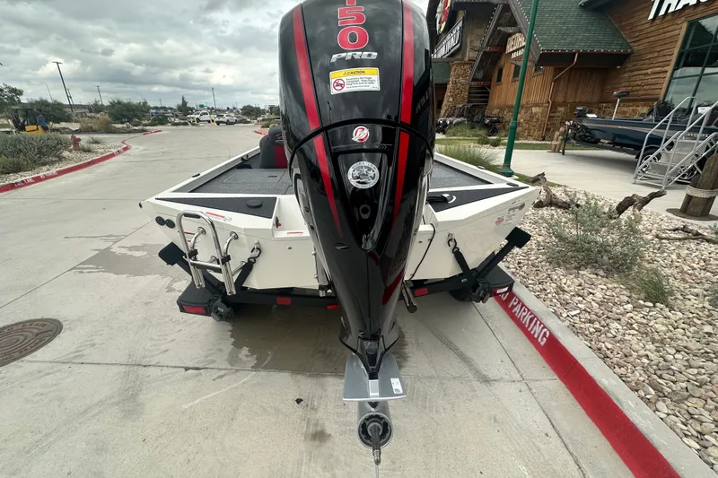 Slide: The Image of 2027 Ranger RT198P boat with powerful outboard motor, parked near rustic building. - 8