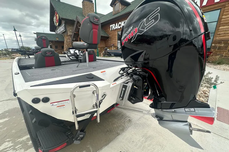 Slide: The Image of 2027 Ranger RT198P boat with Mercury Pro XS engine, parked outside a rustic building. - 12