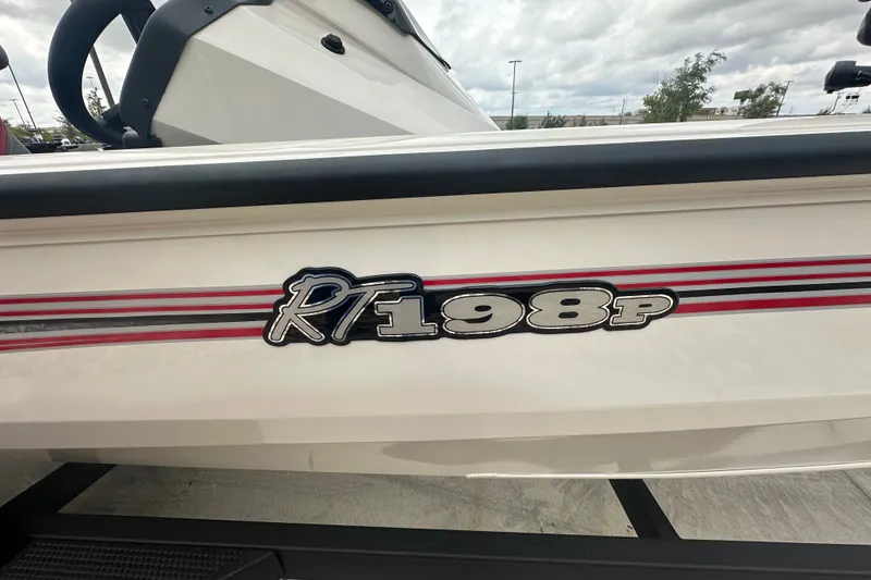 Slide: The Image of 2027 Ranger RT198P boat with red and black stripes on a cloudy day. - 11