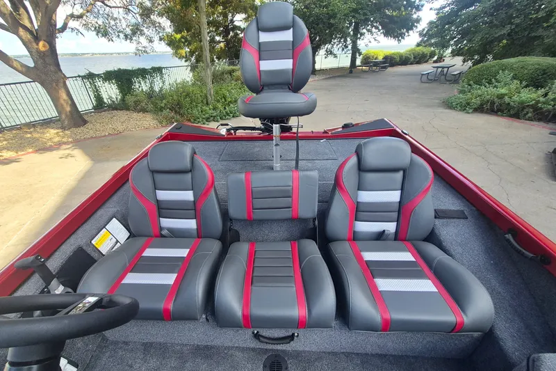 Slide: The Image of 2027 Ranger RT178 boat interior with gray and red seating, lakeside view. - 15