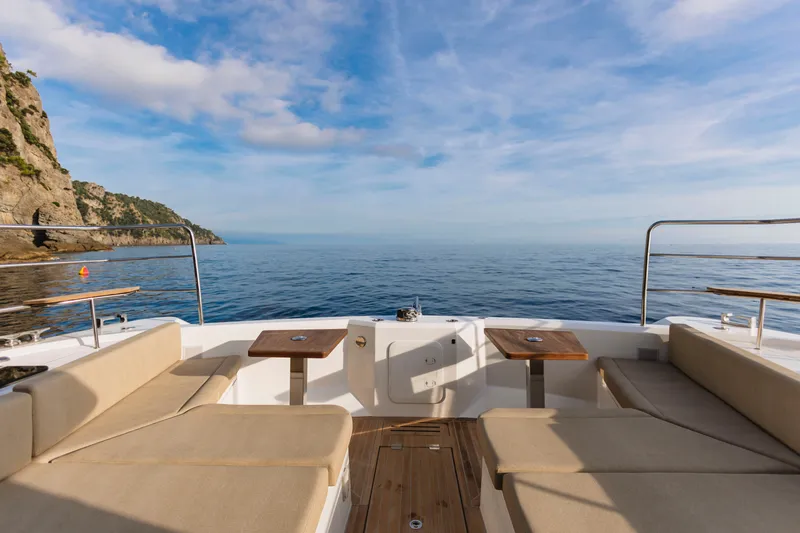 Slide: The Image of Aventura 56 Motor Yacht 2026, luxurious deck view with ocean and cliffs. - 37