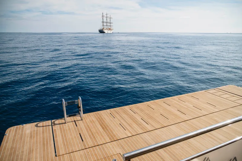 Slide: The Image of Aventura 56 Motor Yacht 2026 deck with ocean view and distant sailboat. - 36